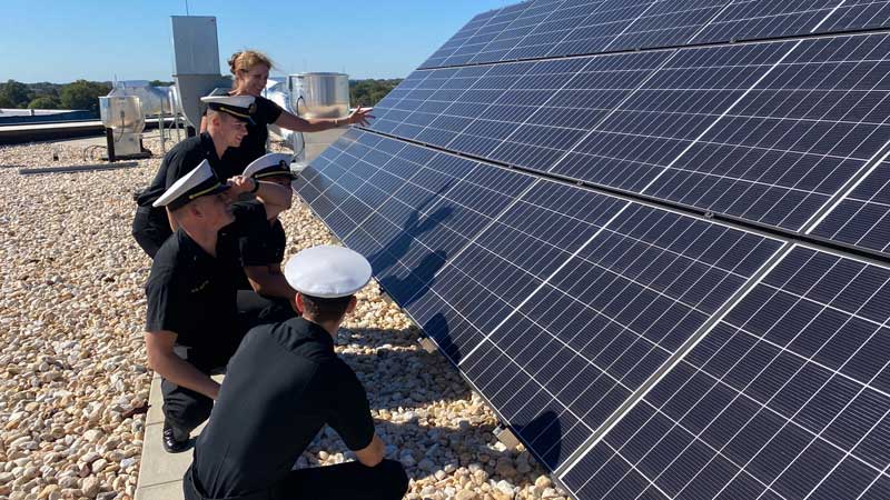 Karen Flack working on a solar panel with students at the United States Naval Academy 